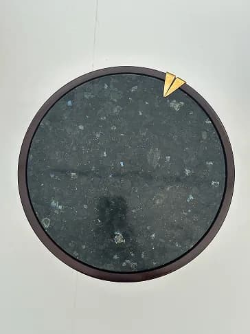 Overhead view of a circular labradorite tabletop with a gold detail.
